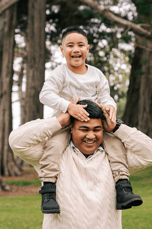 Father carrying child on shoulders outdoors